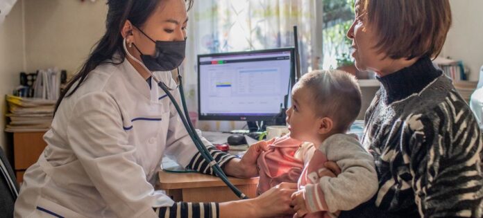 Uma menina de 18 meses recebe suas vacinas de rotina na infância no Quirguistão Uma menina de 18 meses recebe suas vacinas de rotina na infância no Quirguistão